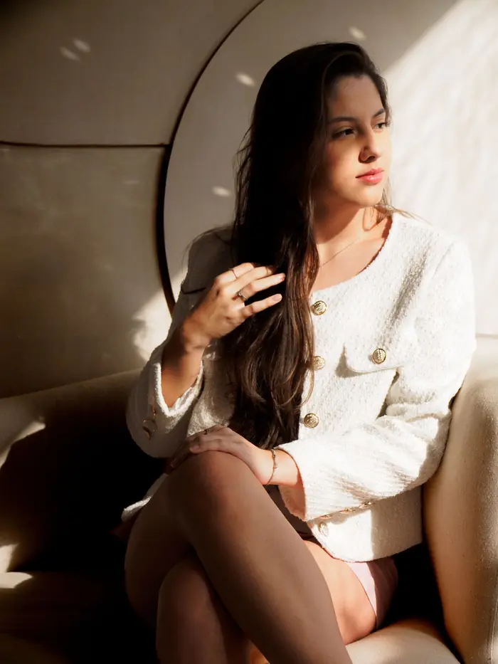 Mulher sentada numa poltrona, em luz natural